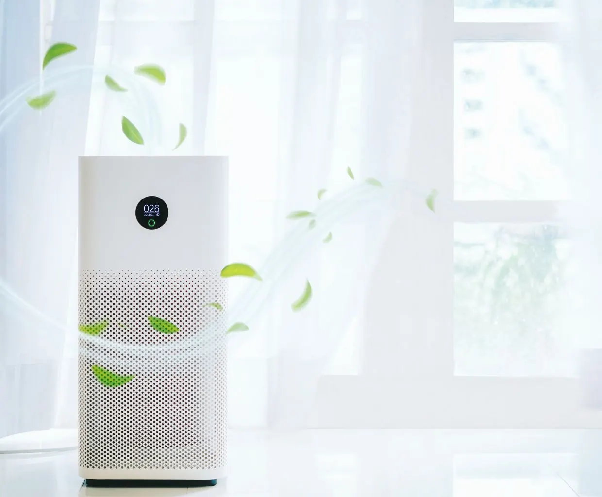 White tower air purifier with a round digital display by a sunlit window, with green leaves drawn swirling around it